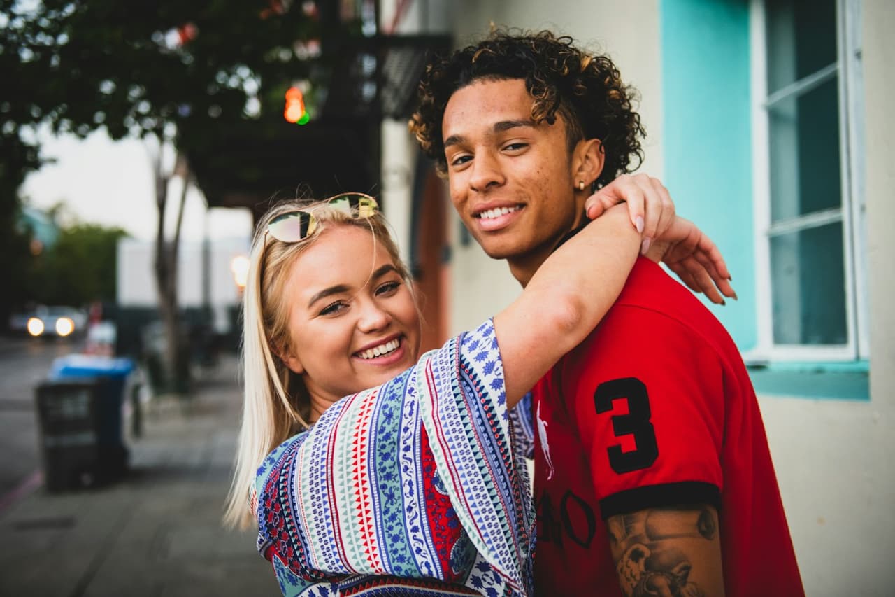 A smiling couple embracing in the city